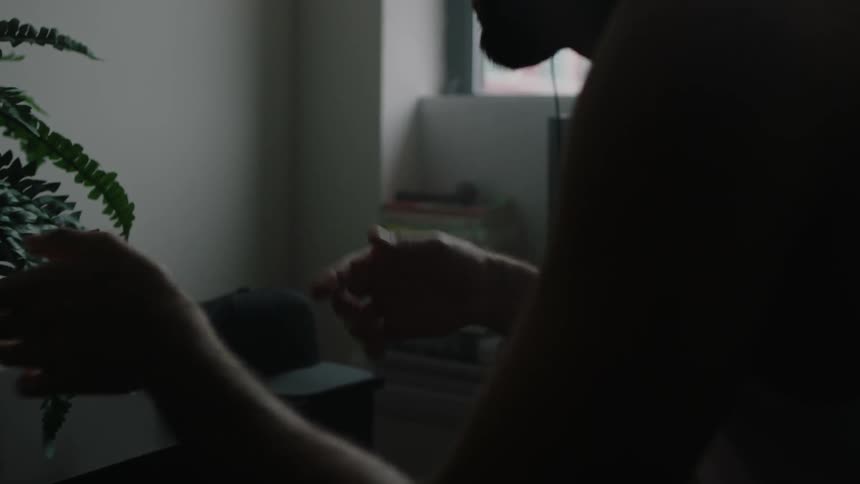 A man is listening to music in his bedroom