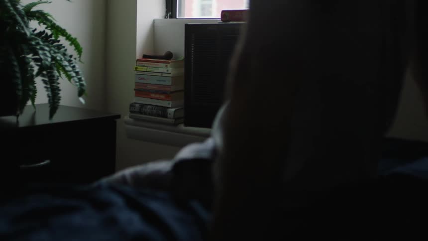 A man sits on the edge of a bed