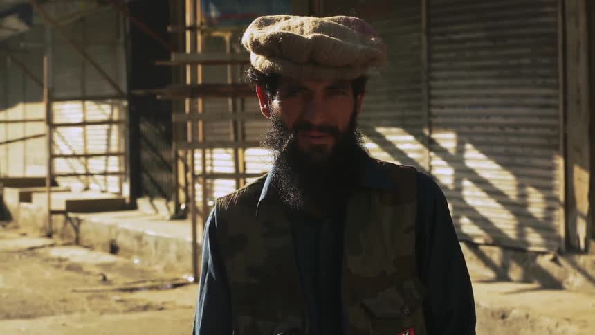 A man is wearing a hat and has a beard