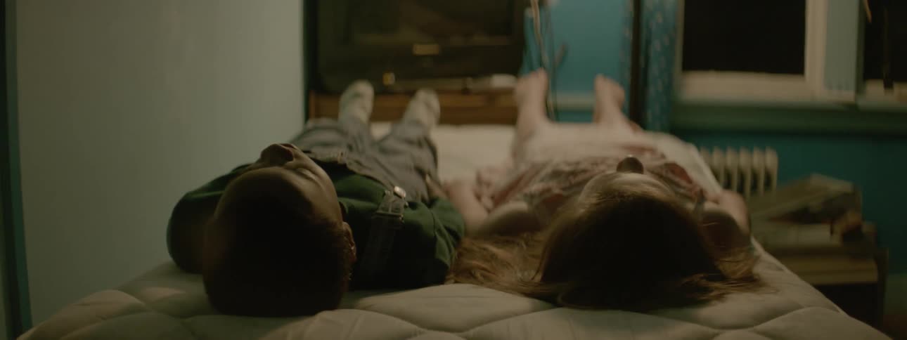 A boy and girl lay on a mattress