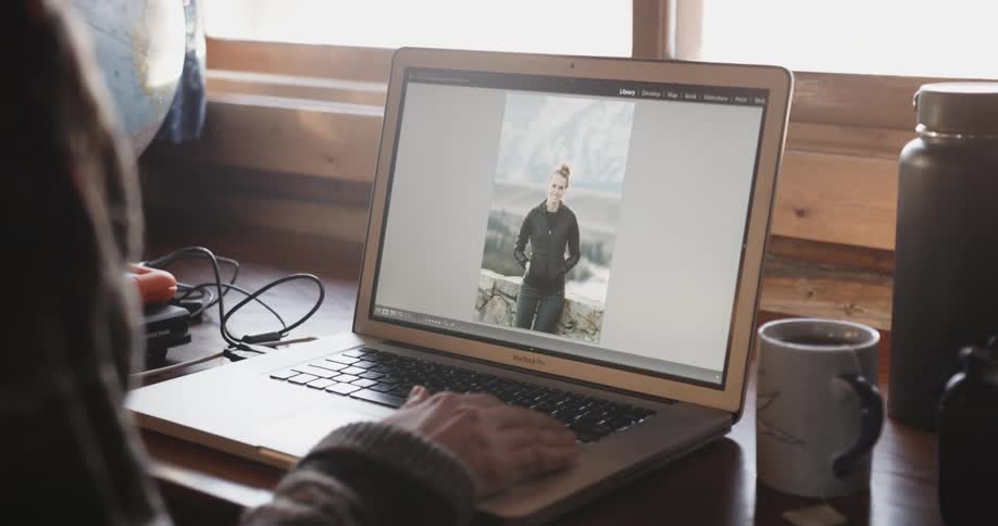 A woman edits pictures on a laptop