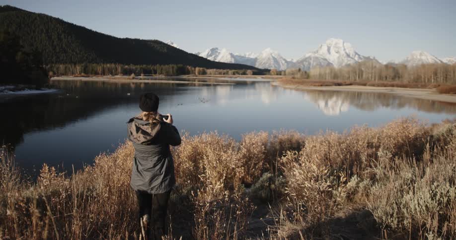 Person taking a picture of lakes and mountains