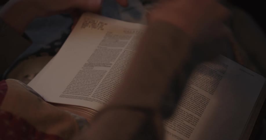 A woman runs her hand over the pages of a bible she is studying