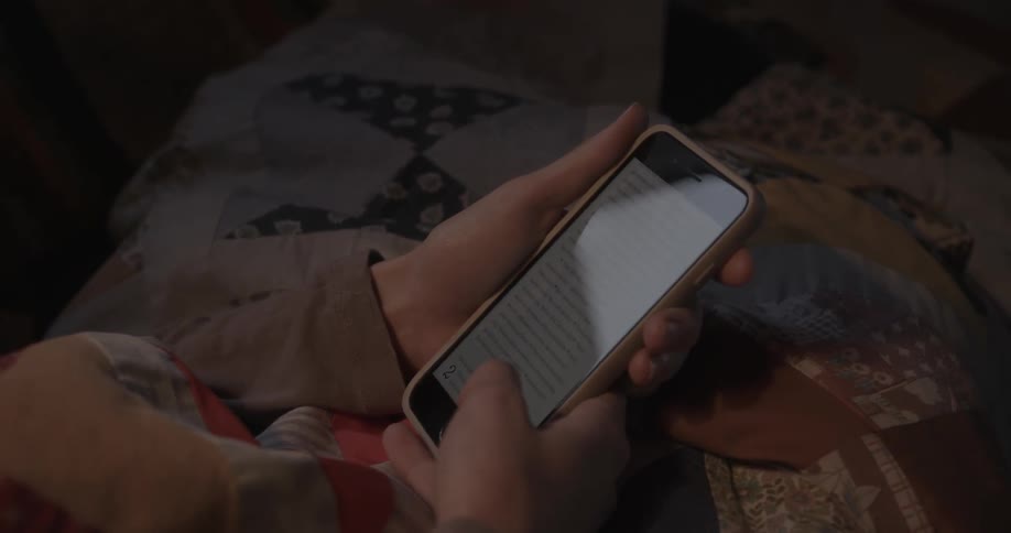 A woman scrolls on her smartphone
