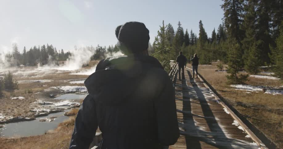 People walk on a wood walkway in a national park
