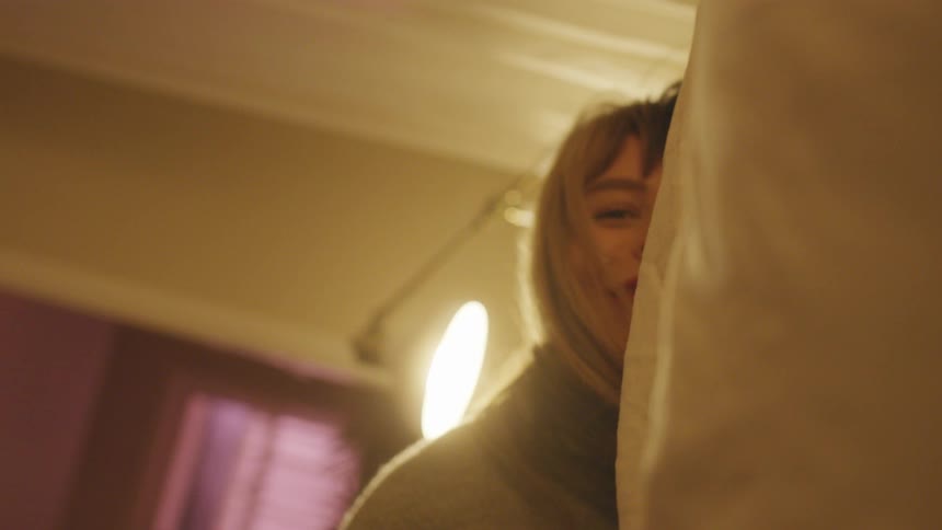 Smiling woman lays down in bed