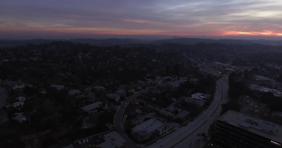 Cars drive on a city highway at sunset