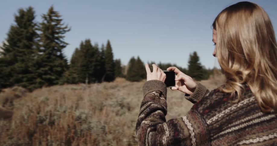 Woman takes pictures of trees