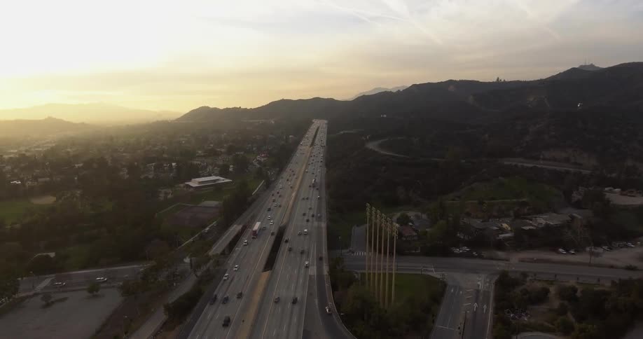 Cars speeding down a highway past a small town