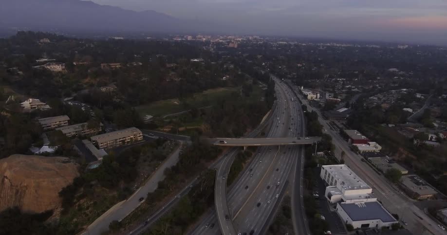 Cars move along a busy interstate at dusk