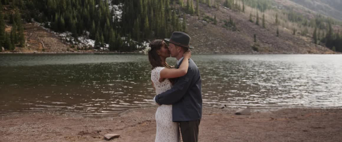 A man and woman kiss near a river