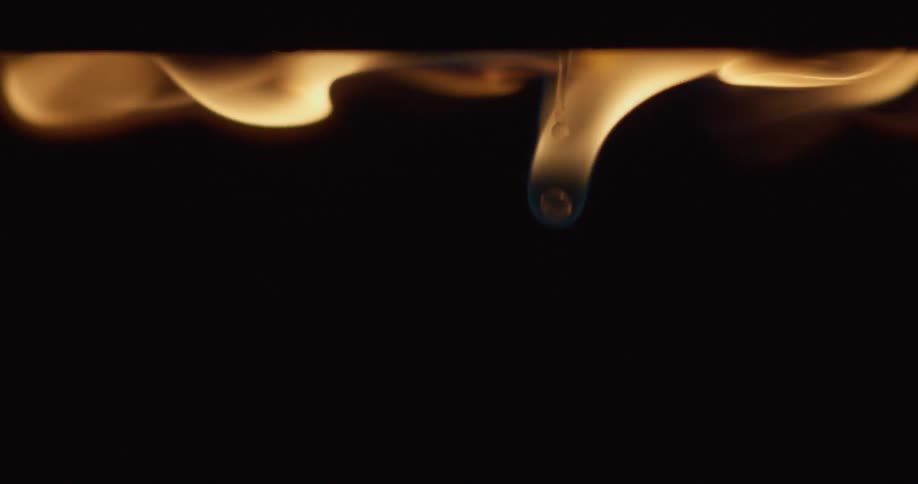 Liquid drips down while a flame burns