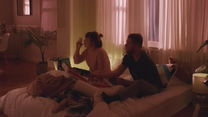 A man and women sit in bed talking