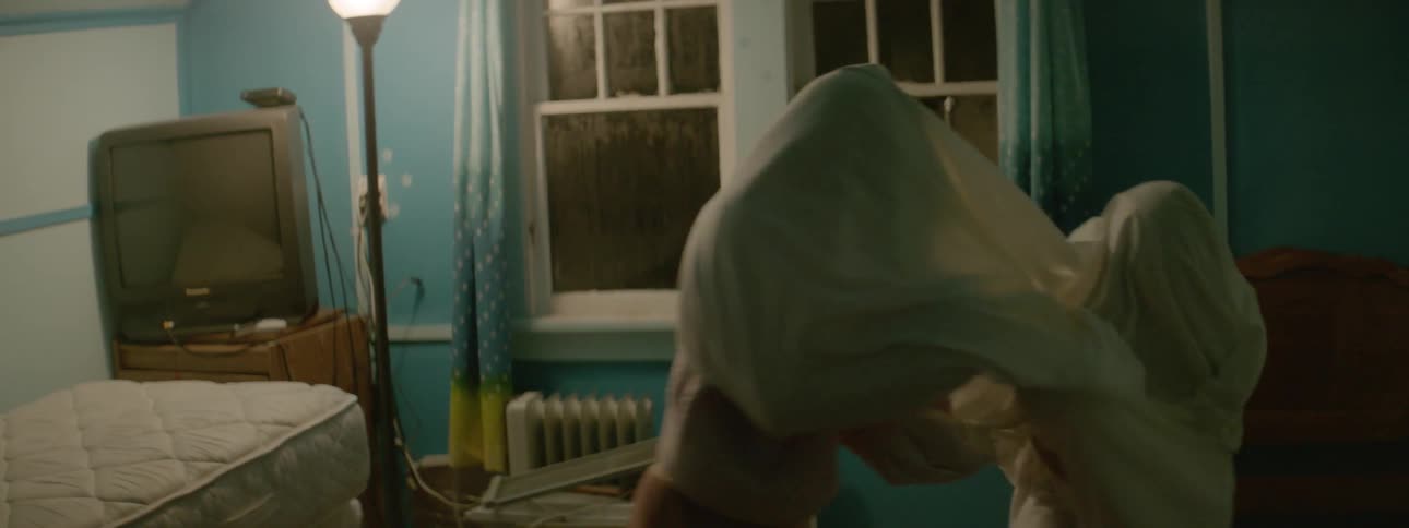 Two girls play beneath a white sheet