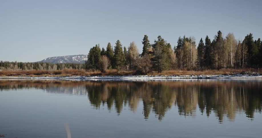 A rippling lake reflects the nearby trees