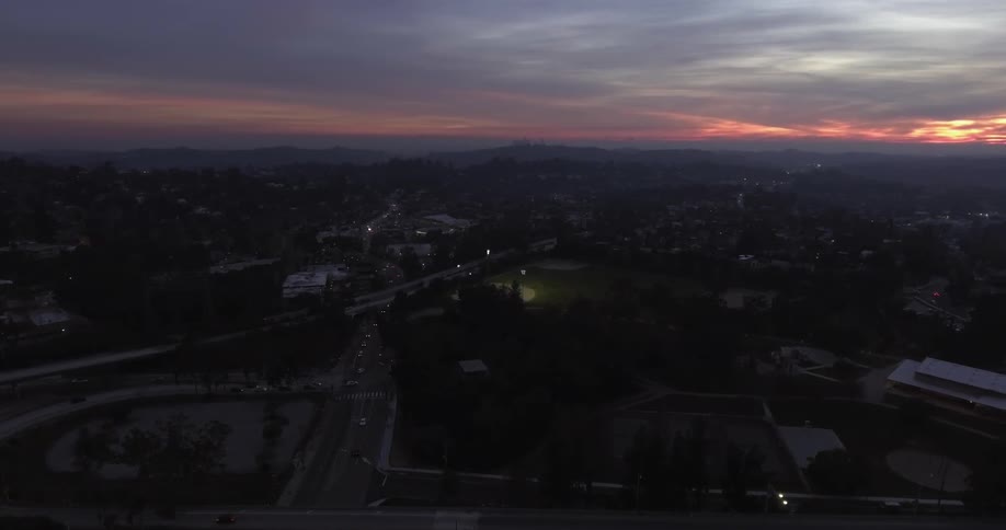 A city is shown at sunset