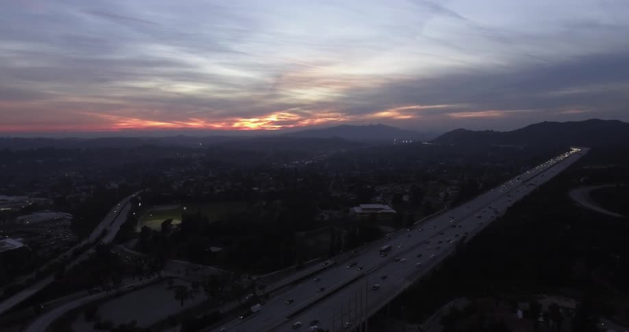 A highway cutting through a city at sunrise