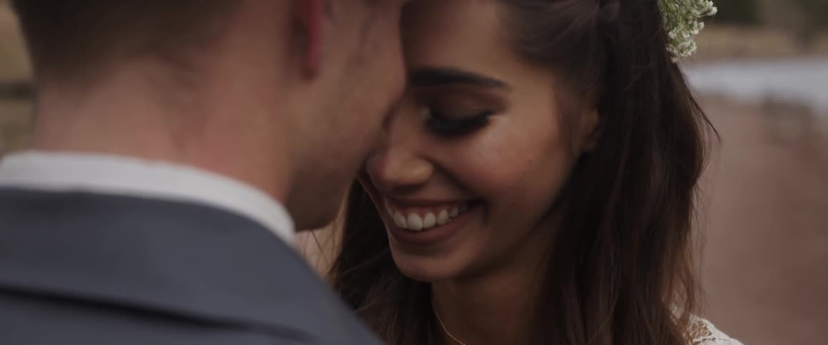 A man and women lean together smiling