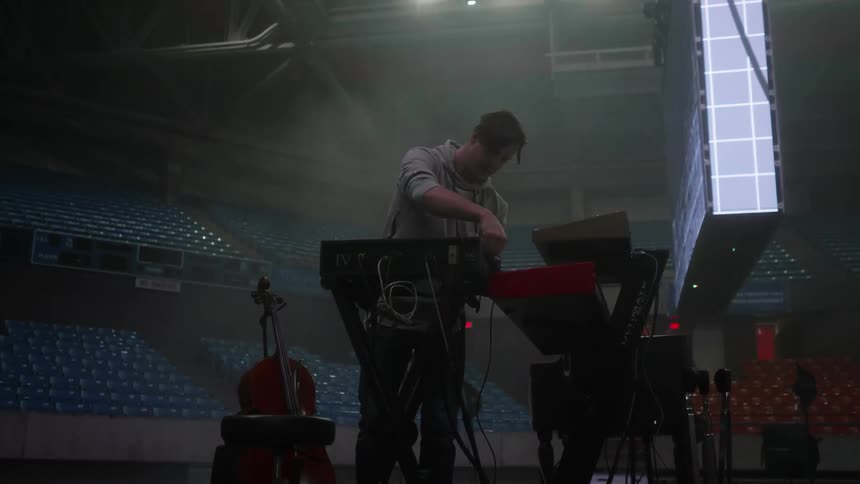 A man plugs in equipment on a stage