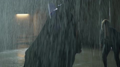 A woman is attacking a large man outside in the rain