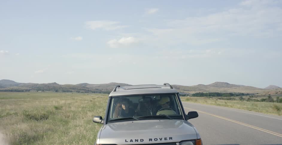 Jeep stopping on the side of a country road as two motorcycles pass
