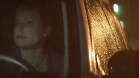 Angry looking woman sitting in a vehicle at night