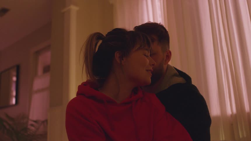 A man and woman hug inside their house