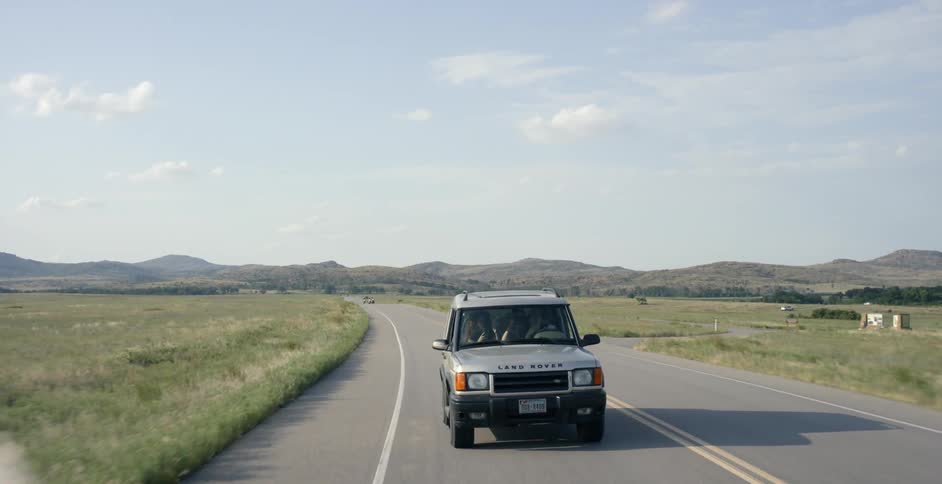 An suv drives along a country road