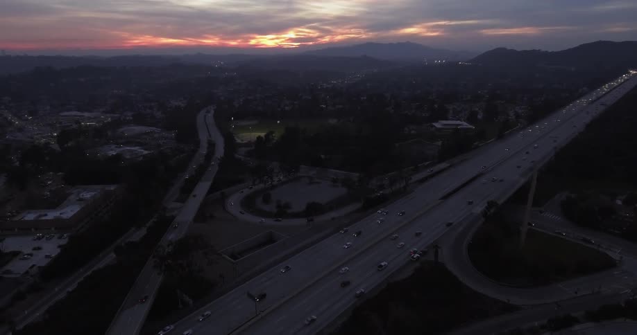 Cars drive on a highway at sunset