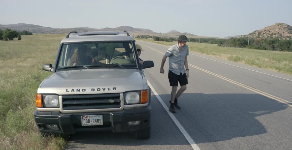 A person gets out of a land rover and walks away