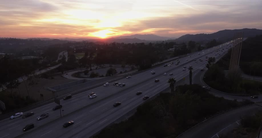Cars drive fast on the highway at dawn