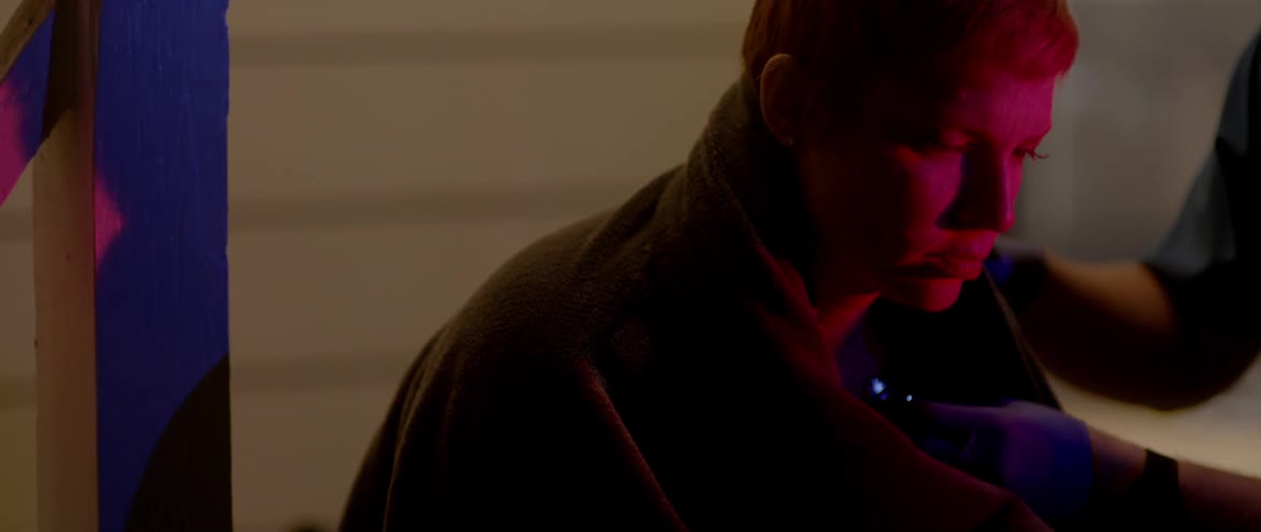 Emergency lights flash on a woman who is being tended to