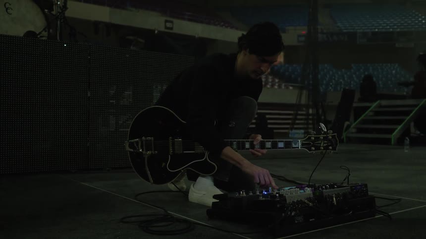 A man is working in a shop with a guitar