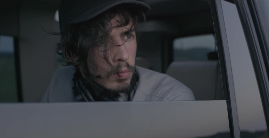 A man staring outside a window of a car