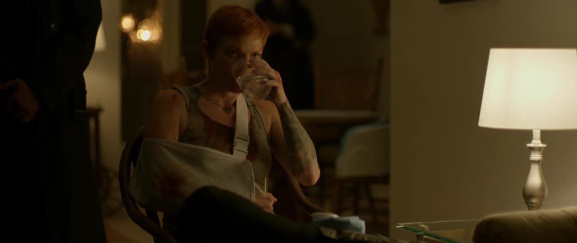 Injured woman drinks out of a glass