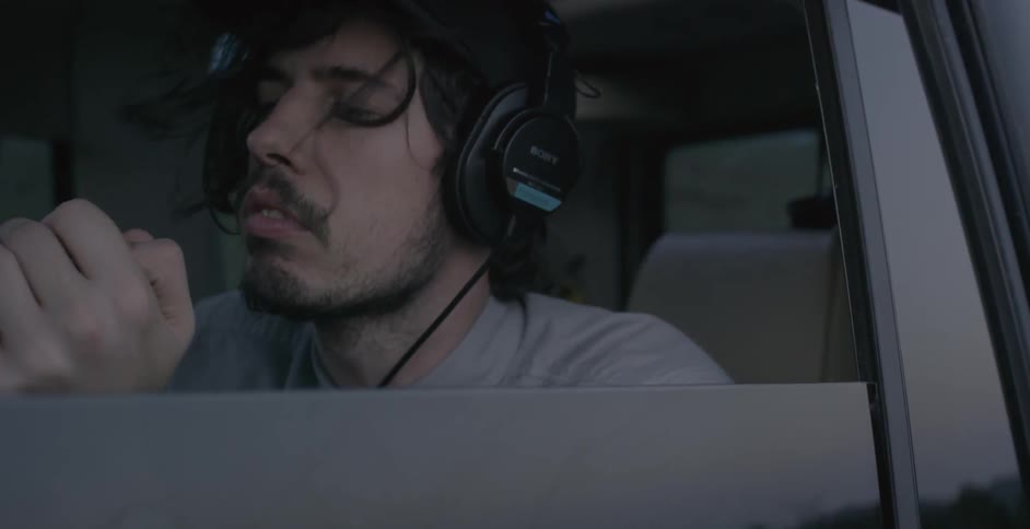 A man in the backseat of a car looking around