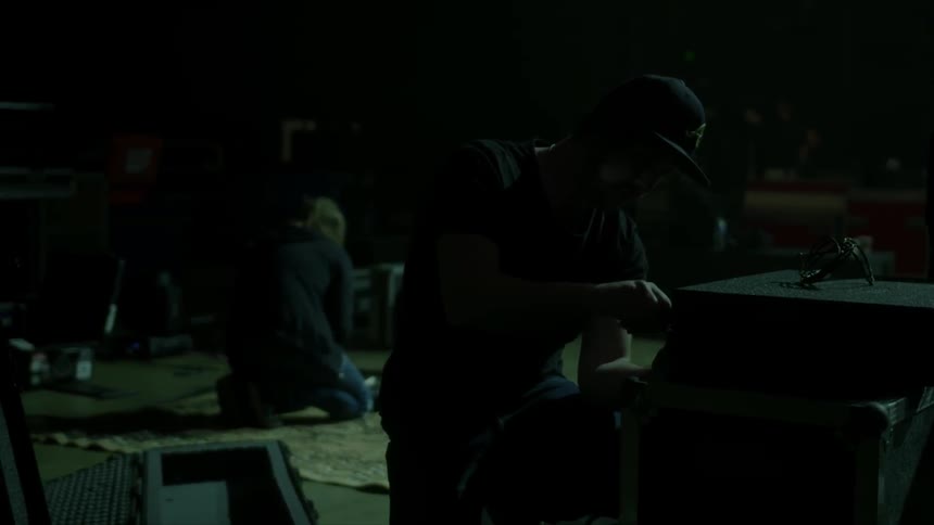 Man fixing a piece of equipment on a stage