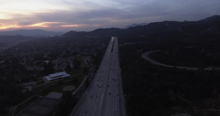 A wide, busy highway at sunrise