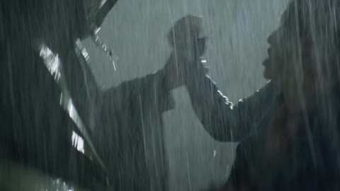 Two people fight each other in the rain at night