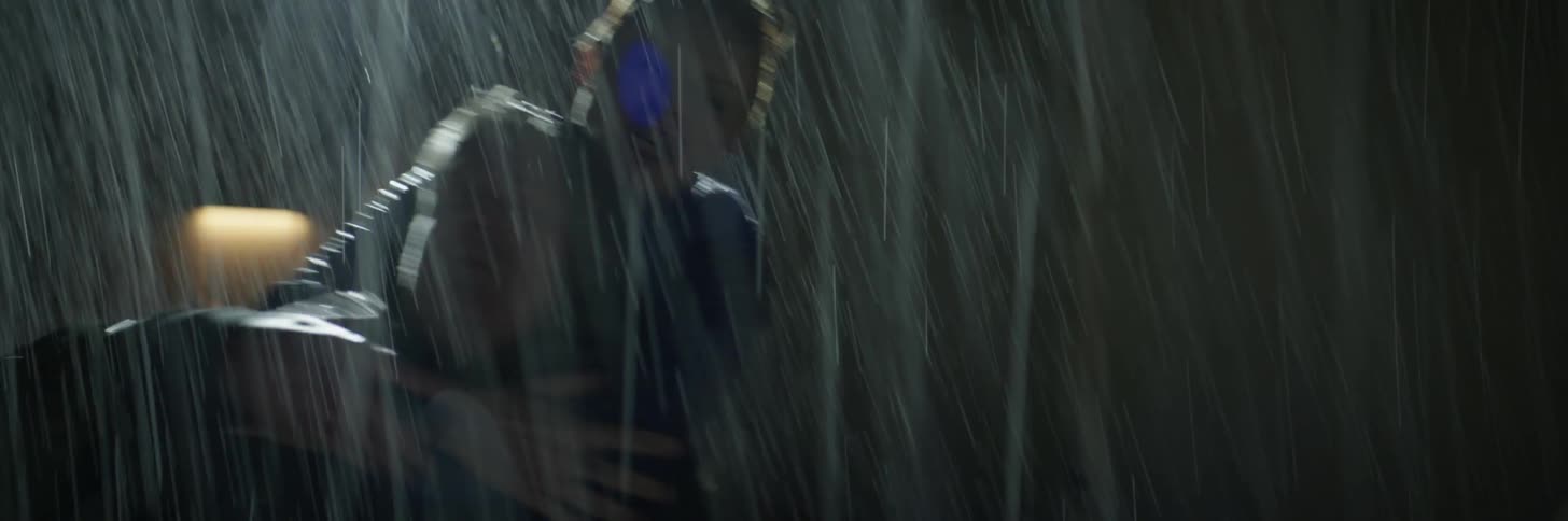 A woman is fighting a man outside at night in the rain