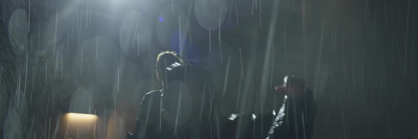Two people fight in a parking lot in the rain