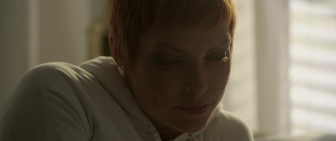 A woman shrugs lightly and blinks