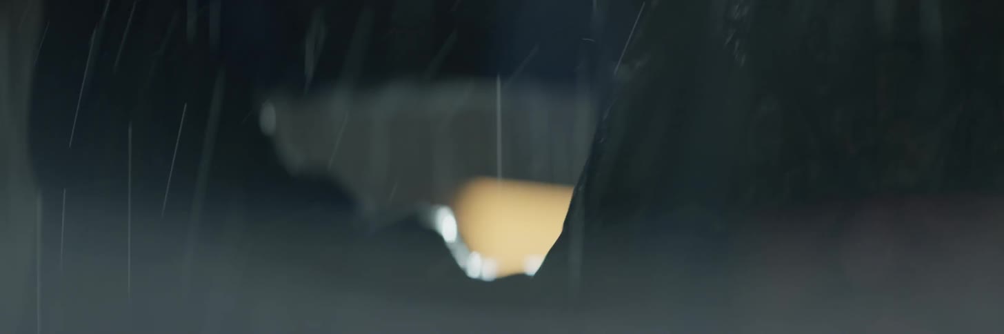 Two people fight outside in the rain