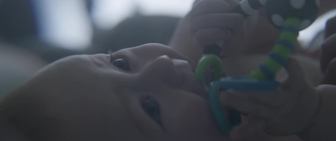 A baby chews on a toy