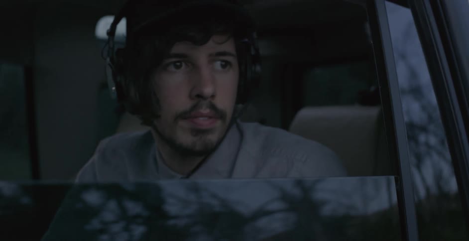 A man sitting in a car looking out the window and driving