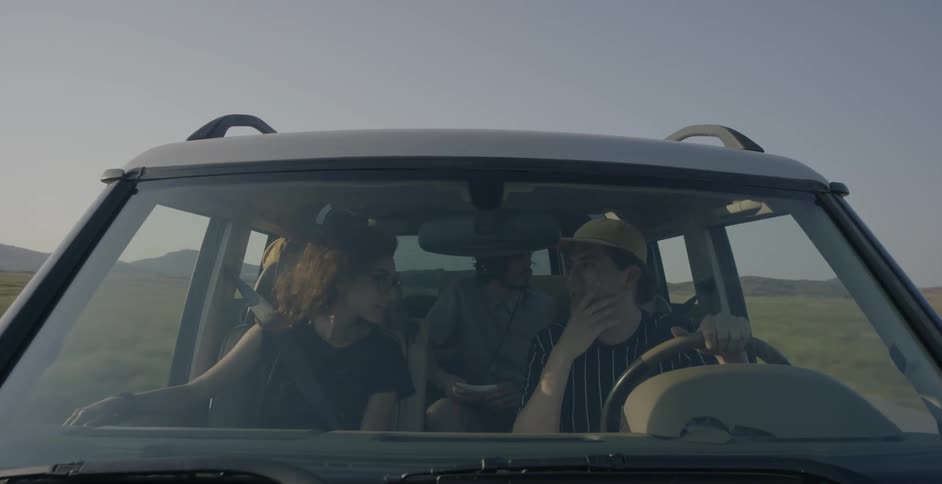 People ride in a vehicle in a rural area on a clear day