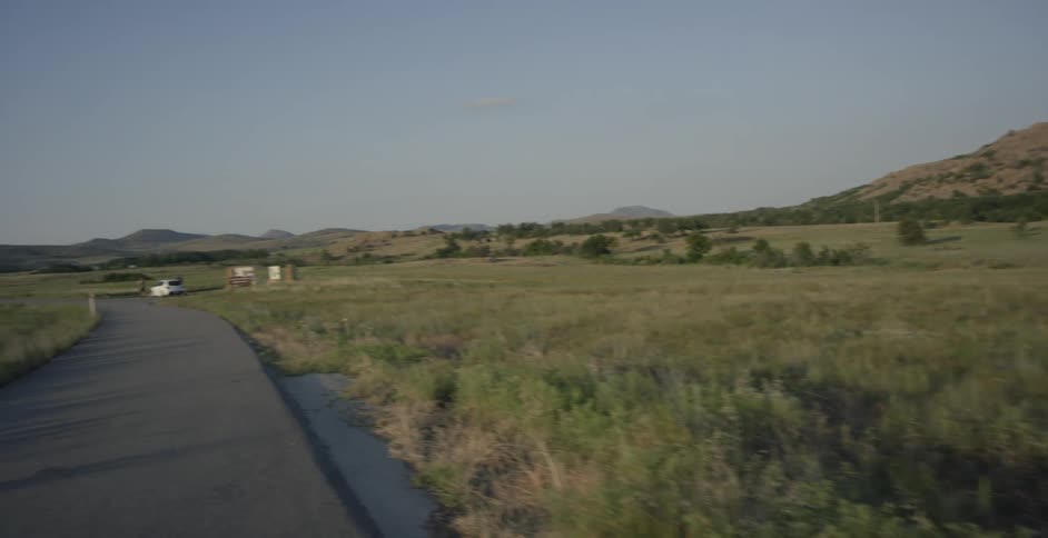 A vehicle passes a pickup truck on a country roads then makes a u-turn