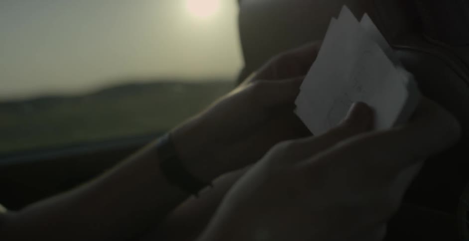 Person sitting down flips through small squares of paper