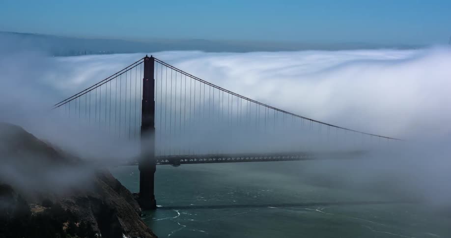 Clouds and fog roll across the golden gate bridge during the day