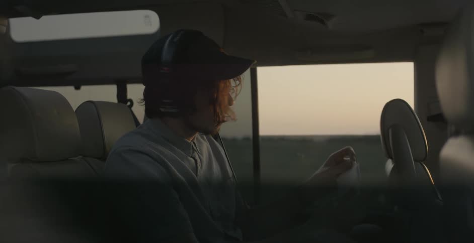 Man sits in a vehicle looking down